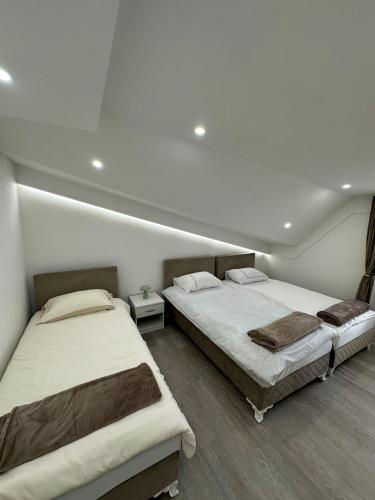 a room with two beds in a room at Čaršija Light Visoko in Visoko