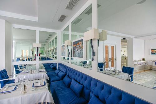 a dining room with a blue couch and tables at Grand Hotel Riviera in Sorrento