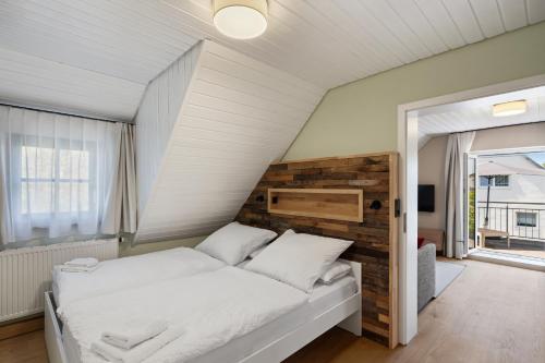 a bedroom with a bed with a wooden headboard at Das BRIX I Apartments zwischen See & Wald in Immenstaad in Immenstaad am Bodensee
