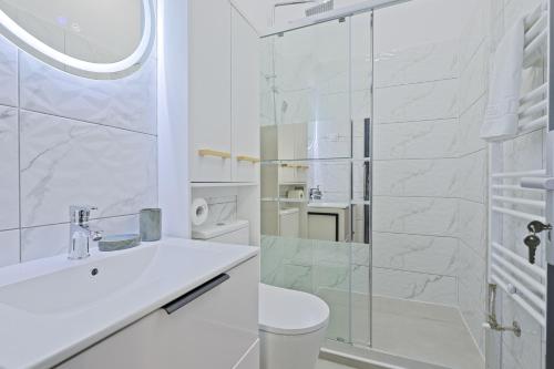 a white bathroom with a toilet and a shower at Kasa KEK - MCMXXV in Mangalia