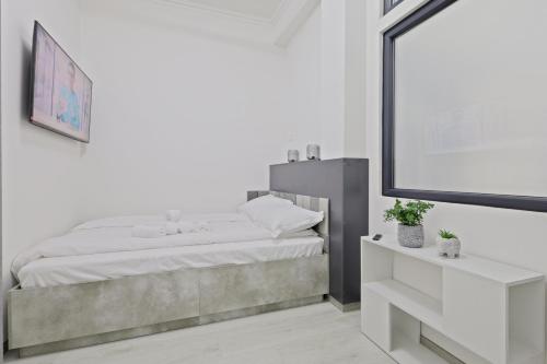 a white bedroom with a bed and a mirror at Kasa KEK - MCMXXV in Mangalia