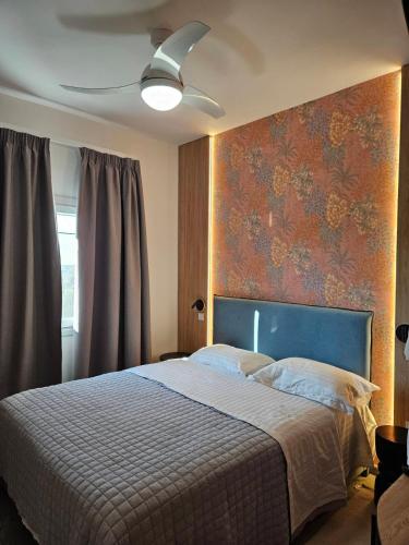 a bedroom with a large bed with a blue headboard at Like home in Samothraki 2 in Kamariotissa