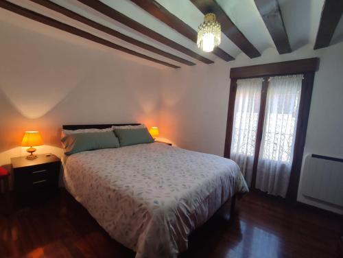 a bedroom with a bed and two lamps and a window at Casona de Barrabás in San Vicente de la Sonsierra