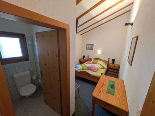 a small bedroom with a bed and a bathroom at Hotel Foppoli in Poschiavo