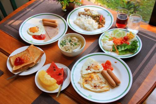 a table with plates of breakfast food on it at Pung-Waan Resort & Spa in Kanchanaburi City