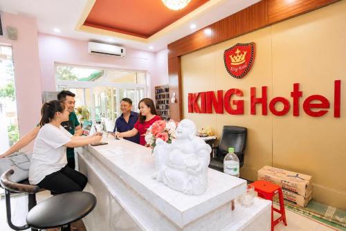 a group of people sitting at a counter at a kings hotel at King Hotel Sầm Sơn in Sầm Sơn