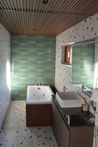 a bathroom with a tub and a sink at Mount n Mist in Ooty