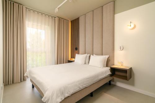 a bedroom with a large white bed and a window at apartamenty-wroc Central Park in Wrocław