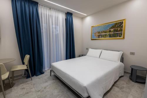 a bedroom with a white bed and blue curtains at Retrait Lake Como Private Design Retreat with Lake View in Perledo