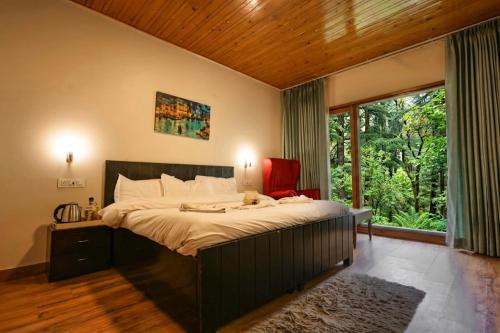 a bedroom with a large bed and a large window at The Woodlane Cottage in Kūfrī