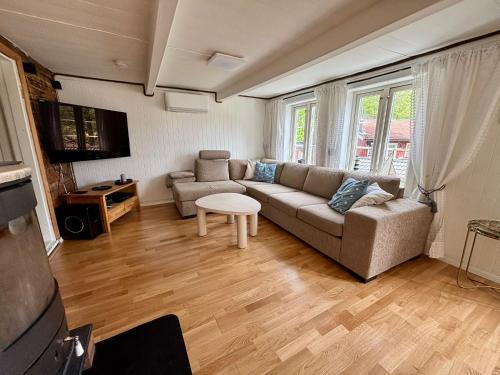 a living room with a couch and a table at Sørlandshus med 3 soverom in Arendal