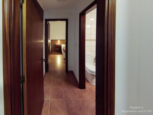 einen Flur eines Badezimmers mit WC und Waschbecken in der Unterkunft Hospetur 2 in Horta