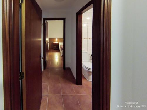 a hallway of a bathroom with a toilet and a sink at Hospetur 2 in Horta