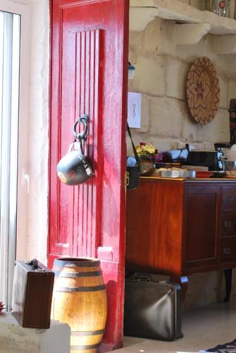 a red door in a kitchen with a pot at Secco's Seaview Accommodation in Mġarr