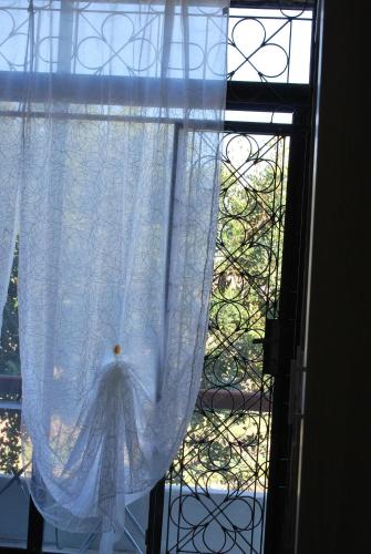 a window with a white curtain in a room at Secco's Seaview Accommodation in Mġarr