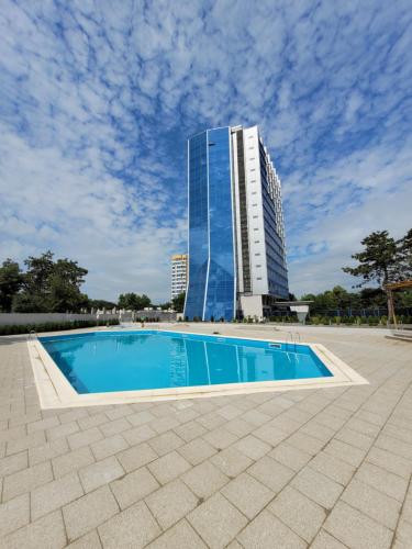 a swimming pool in front of a tall building at Olimp Panoramic Sea View in Olimp