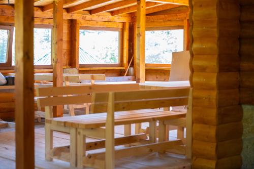 a dining room in a log cabin with windows at Katun Senic in Berane