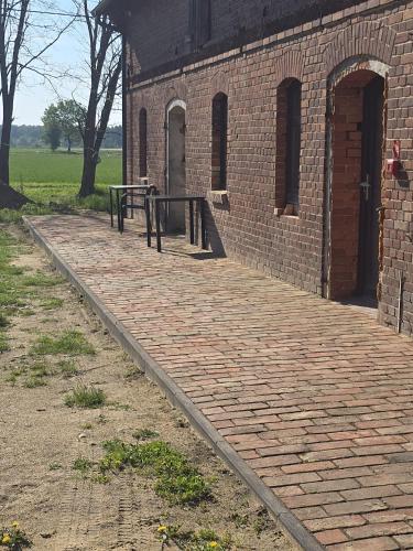 a brick building with a bench on the side of it at Dom w Młodzianowie in Milicz