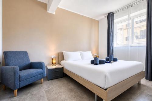 a bedroom with a bed and a blue chair at Modern Maisonette with Valley Views KARP1-3 in San Ġwann
