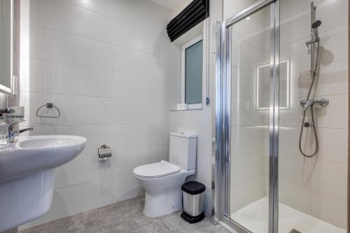 a bathroom with a toilet and a sink and a shower at Modern Maisonette with Valley Views KARP1-3 in San Ġwann