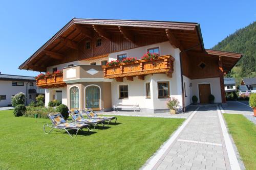 una casa con due sedie a sdraio e un balcone di Familie Meilinger - Werfenweng Ferienappartement a Werfenweng