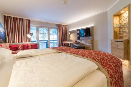 a hotel room with a large bed and a television at Wohlfühlhotel Schiestl in Fügen