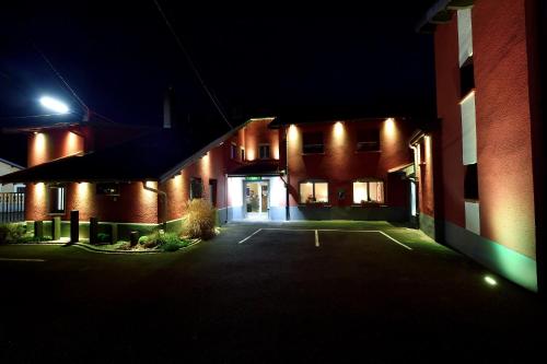 a building with a parking lot at night at Relais Vosgien - Hôtel Restaurant "la Table de Sophia" in Saint-Pierremont