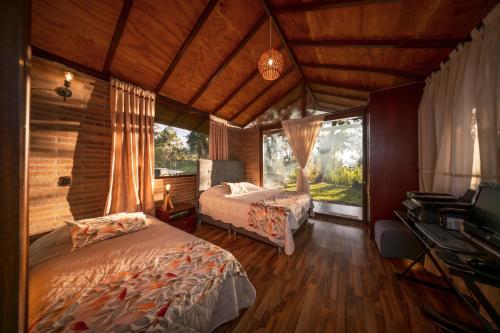 a bedroom with two beds and a television in it at Las Cabañas La Libertad in Macanal