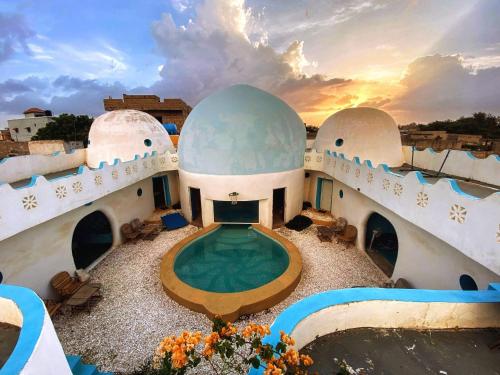 a house with a swimming pool and a sunset at la maison blanche du lac in Niaga