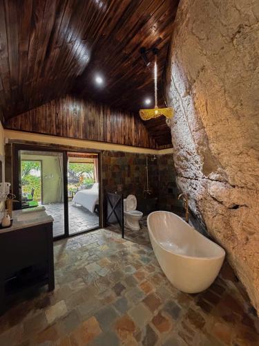 a large bathroom with a tub and a bedroom at Tràng An Valley Garden in Ninh Binh