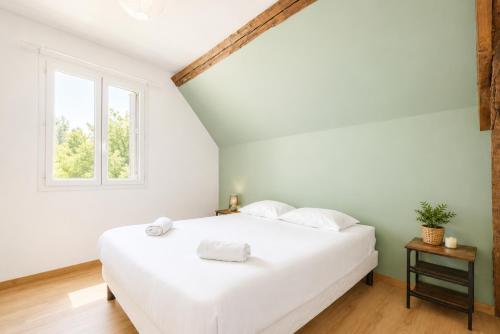 a white bed in a room with a window at Cacatoès in Saint-Aignan