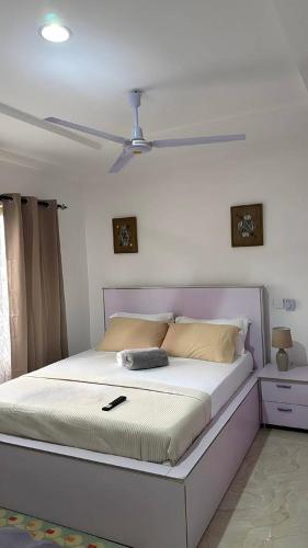 a bed in a bedroom with a ceiling fan at Casa Leo in Agboogba