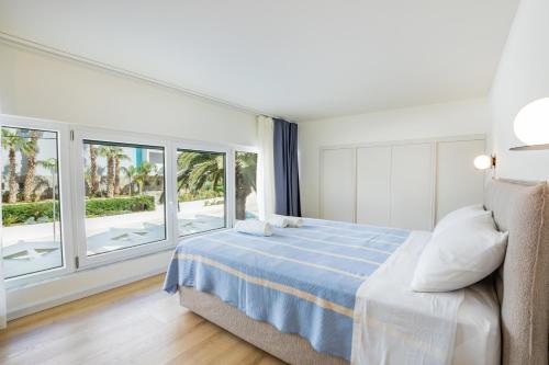 a bedroom with a bed and large windows at Ble city in Karpathos