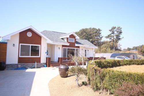 a house with a vase in front of it at Mongsanpo High Beach Pension in Taean