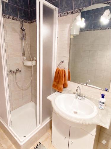 a bathroom with a sink and a shower at Szende Apartman in Balatonfüred