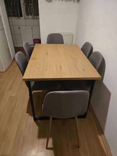 a wooden table with chairs in a room at Perla Central Apartment in Zalău