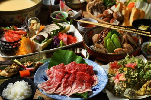 a table filled with different types of food on plates at 六日町温泉 龍氣 in Minami Uonuma