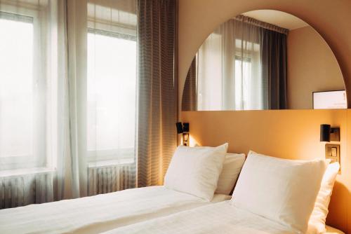 a bedroom with a white bed and a mirror at Scandic Go, Kungsgatan 14 in Jönköping