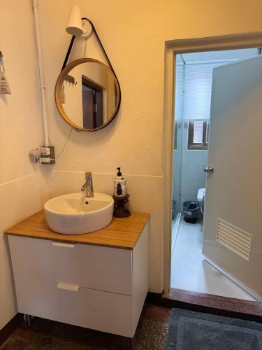a bathroom with a sink and a mirror on the wall at 海軍官邸眷村民宿 in Nan-men