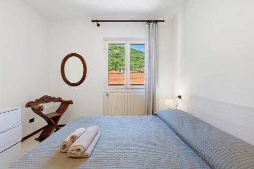 a bedroom with a bed with a mirror and a window at Casa Ezia in Porlezza