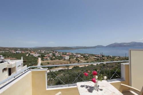 a balcony with a table and a view of the water at Villa Christine - Maisonettes with fireplace in Aliveri