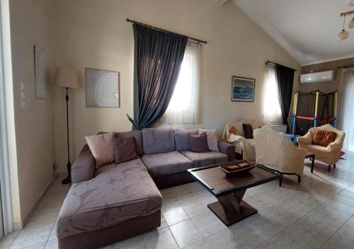 a living room with a couch and a table at Villa Alexandra Rio Patra in Áyios Vasílios