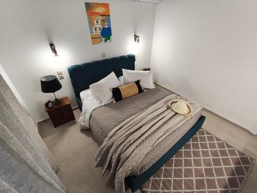 a bedroom with a bed with a blue headboard at Prikas Apartments A in Kefalos