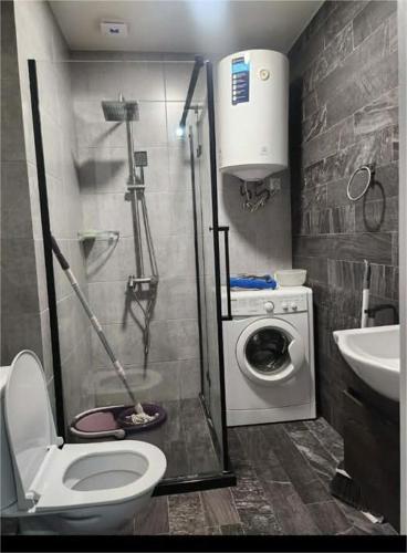 a bathroom with a toilet and a washing machine at Gio apartment in Angisa