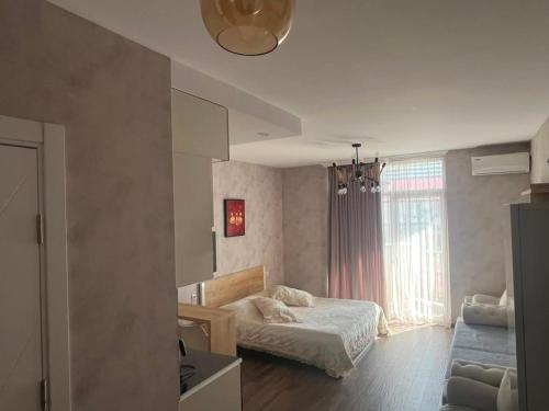 a bedroom with a bed and a window and a couch at Gio apartment in Angisa