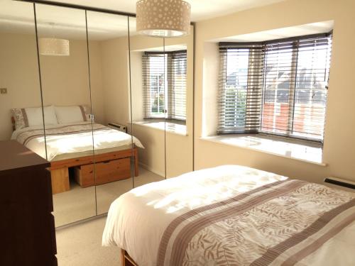 a bedroom with two beds and two windows at Campbell Apartment in Cardiff