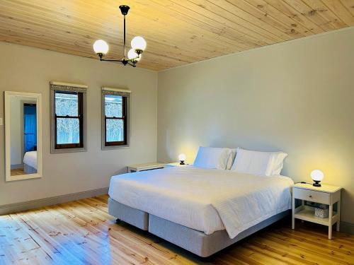 ein Schlafzimmer mit einem großen Bett und einer Holzdecke in der Unterkunft Tread Lightly Willunga Cabins in Willunga