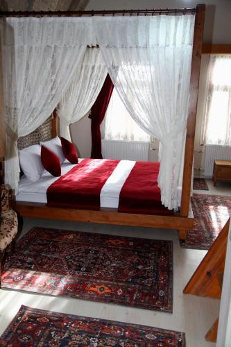 a bedroom with a bed with red and white curtains at Karballa Hotel in Aksaray