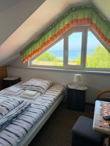 a bed in a room with a large window at Pokoje Gościnne Strażnica in Jarosławiec