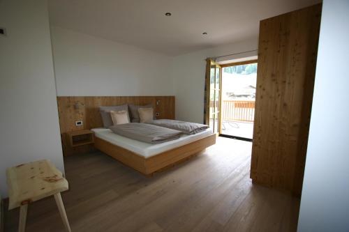 a bedroom with a bed and a sliding glass door at Hilpoldhof in Castelrotto